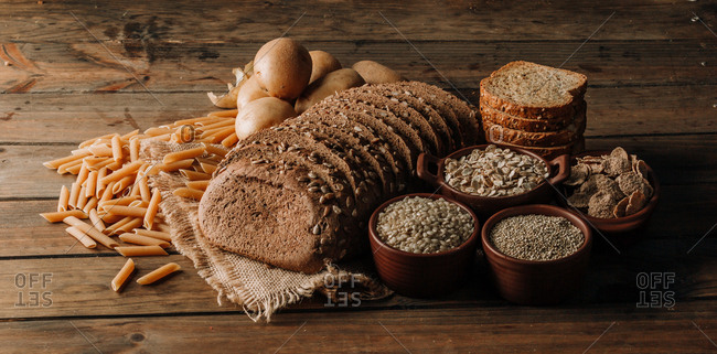 Wholegrain food pasta and freshly baked rye bread on table