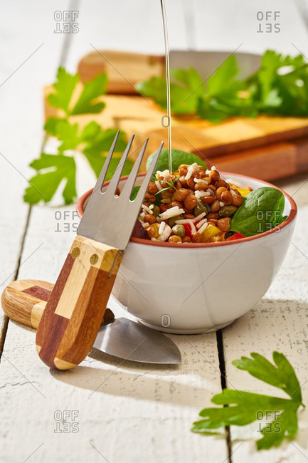 From above appetizing colorful cut vegetable mix with spinach lentils and rice on wooden background