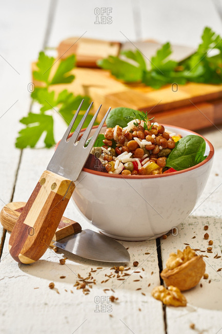 From above appetizing colorful cut vegetable mix with spinach lentils and rice on wooden background