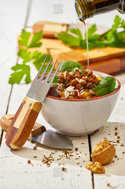 From above appetizing colorful cut vegetable mix with spinach lentils and rice on wooden background