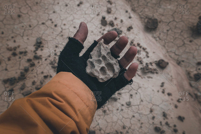 Stone in hand on dry desert area