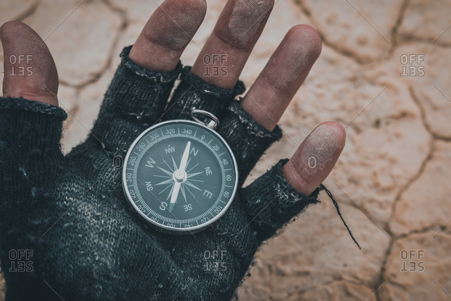 Compass in hand on dry desert area