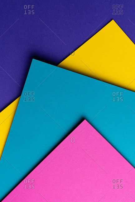 From above layout of colorful cardboard sheets in blue, purple, pink and yellow shades