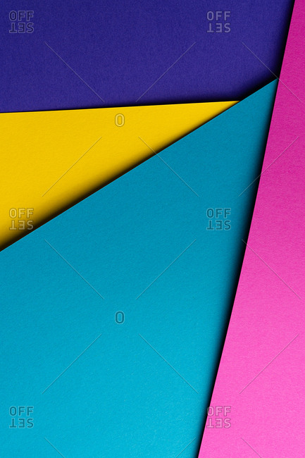 From above layout of colorful cardboard sheets in blue, purple, pink and yellow shades