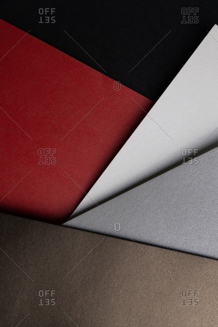 From above layout of pastel glitter cardboard sheets in brown, white, red and grey shiny shades