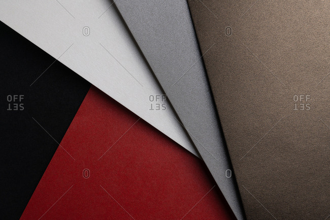 From above layout of pastel glitter cardboard sheets in brown, white, red and grey shiny shades