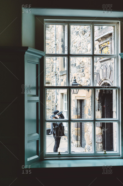 View through old window frame with aged stone building behind in soft daylight, Scotland