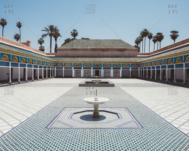 June 25, 2019: Patio with colorful tiled floor and fountains surrounded with covered gallery and pillars in oriental style, Marocco