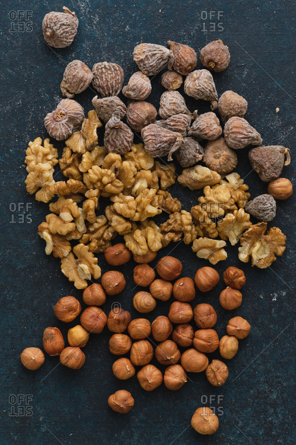 Flat lay with various nuts and dried fruits: hazelnuts, walnuts and figs