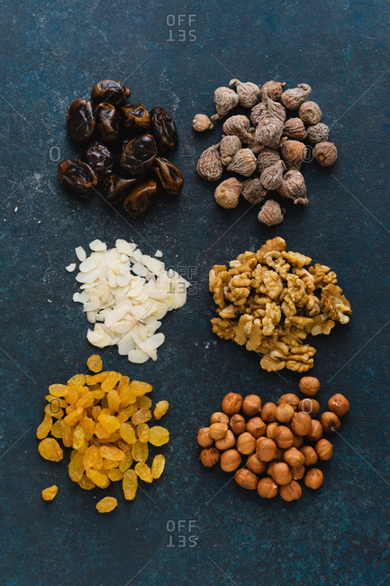 Flat lay with various nuts and dried fruits: hazelnuts, walnuts, raisins