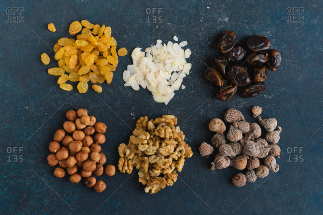 Overhead view of various nuts and dried fruits: hazelnuts, walnuts, raisins