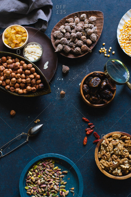 Various nuts and dried fruits: hazelnuts, walnuts, raisins on dark background