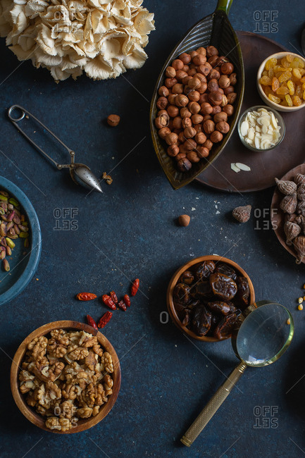 Overhead view of various nuts and dried fruits: hazelnuts, walnuts, raisins