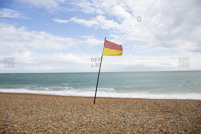 Beach flag showing limit of swimming area, Brighton, England