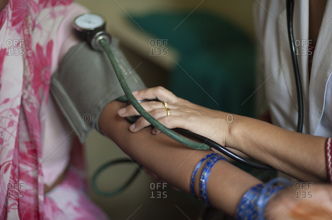 A doctor checks a patients blood pressure in a hospital in Nepal