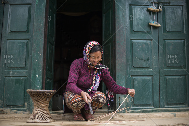 A woman makes a stool from strips of bamboo
