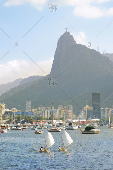 Rio De Janeiro, Brazil - June 15, 2014: Two boys sail in the Botafogo bay, Corcovado mountain in the background