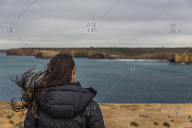 Female looks out at the ocean on a stormy day on the Great Ocean Road