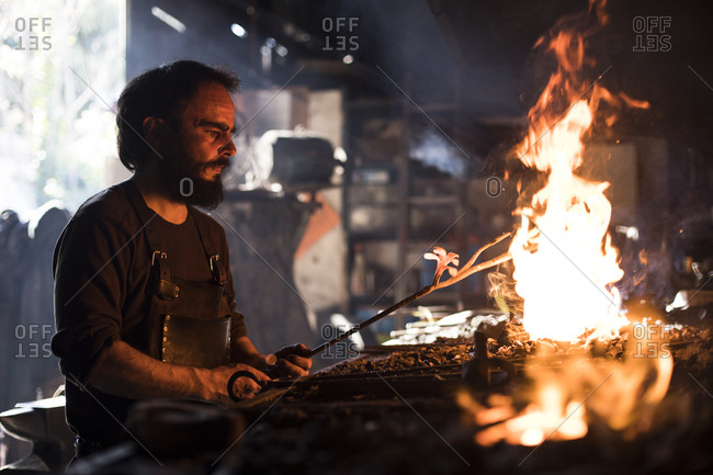 Blacksmith heating iron in fire