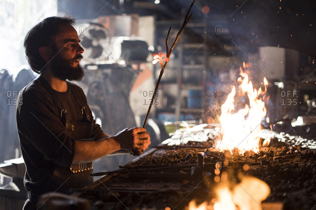 Blacksmith heating iron in fire