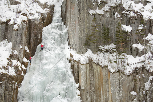 Two people are climbing a frozen waterfall in Sounkyo Gorge, Daisetsuzan National Park, Hokkaido, Japan.