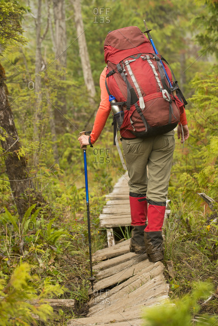 Backpacker hiking along boardwalk, West Coast Trail, British Columbia, Canada