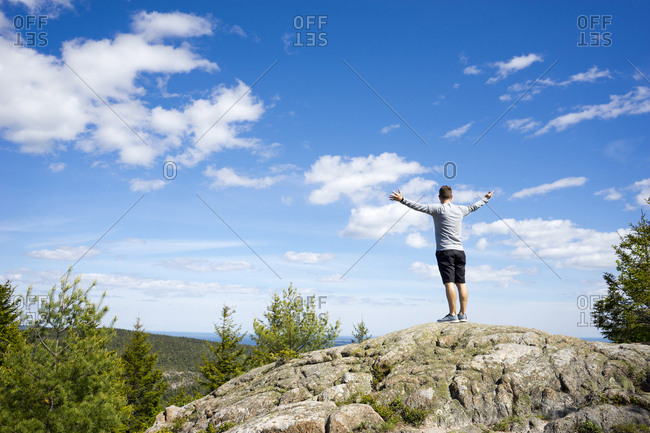 Man with his arms up in an "on the top of the World" pose after hiking to the top of Beech Mountain