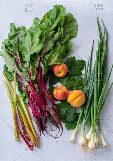 Fresh harvest haul of  fruits and vegetables from the farm  beets, rhubarb, onions, peaches and strawberry with blackcurrant leaves