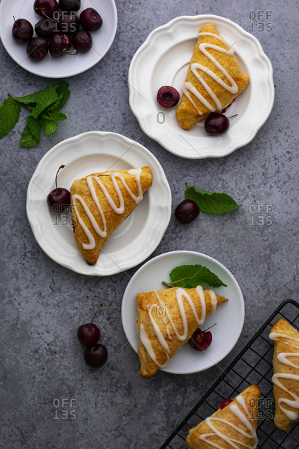 Flaky turnovers with cherry filling are plated on a white plate once they are cooled down.