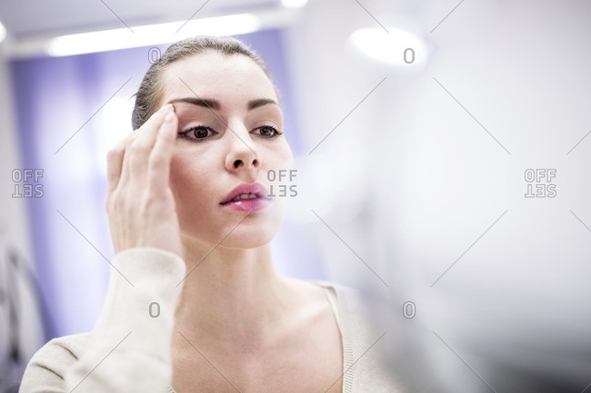 Woman looking in mirror in clinic.