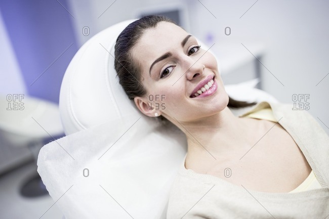 Portrait of young woman lying on couch in clinic.
