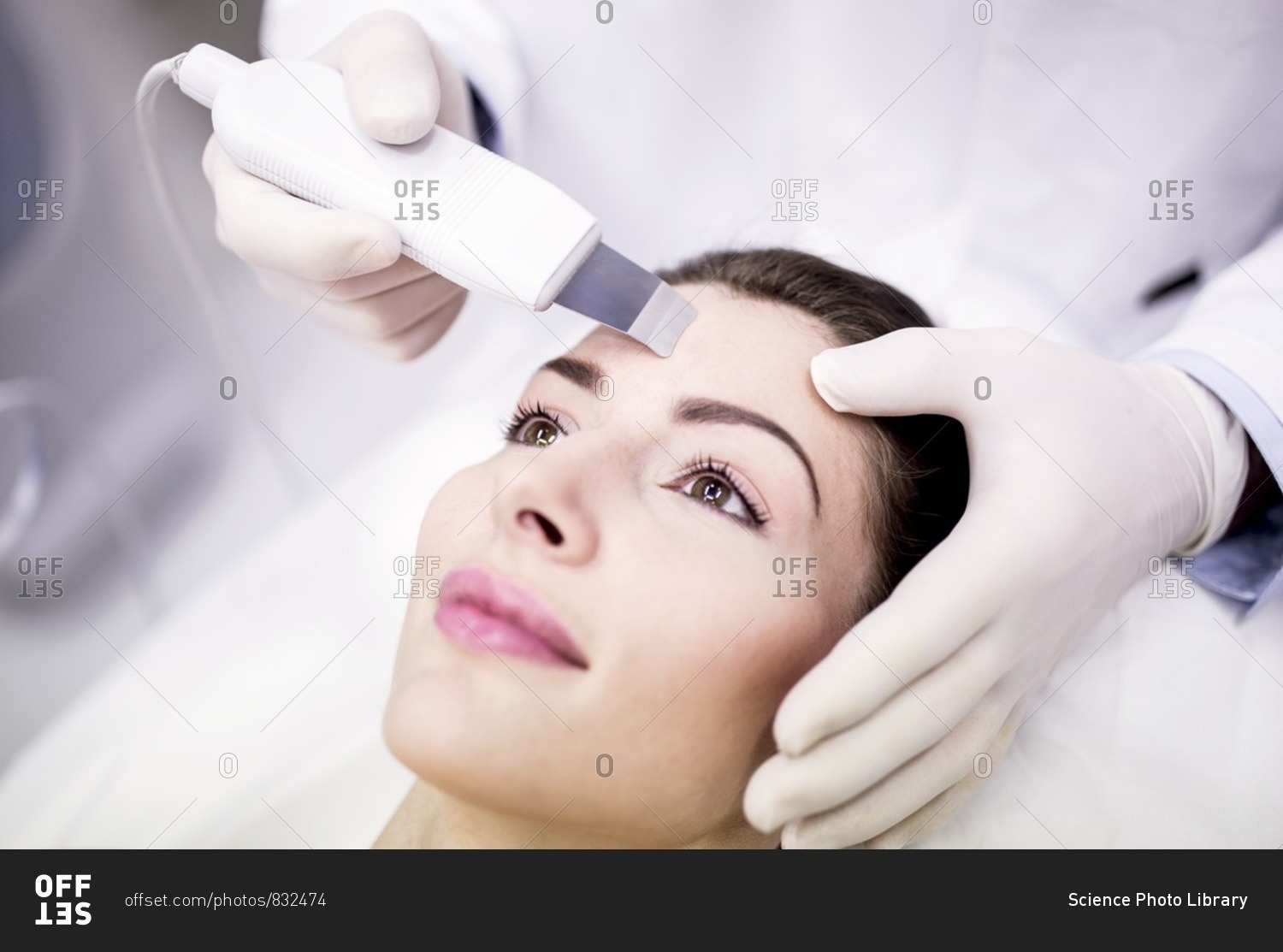 Young woman receiving facial microdermabrasion treatment in clinic, close-up. The cosmetic procedure uses micro crystals to remove dead skin cells. This exfoliating treatment can stimulate the production of collagen and help improve fine lines and acne sc
