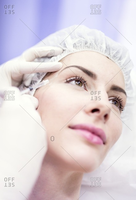 Beauty technician injecting botox into a woman's face. Botox is used medically to treat certain muscular conditions and cosmetically to reduce wrinkles. It is made from a neurotoxin called botulinum toxin and works by temporarily paralyzing muscles.