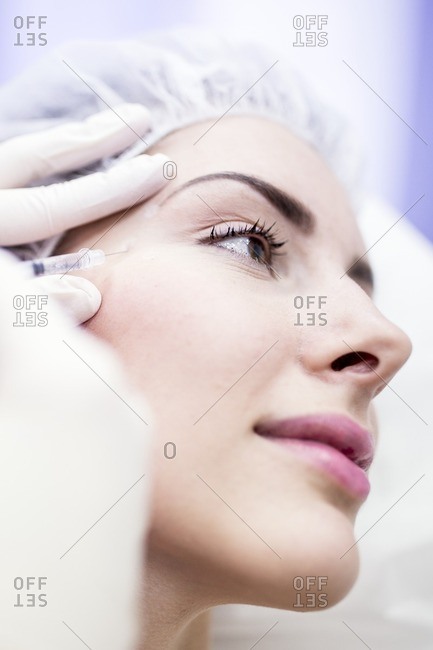 Beauty technician injecting botox into a woman's face. Botox is used medically to treat certain muscular conditions and cosmetically to reduce wrinkles. It is made from a neurotoxin called botulinum toxin and works by temporarily paralyzing muscles.