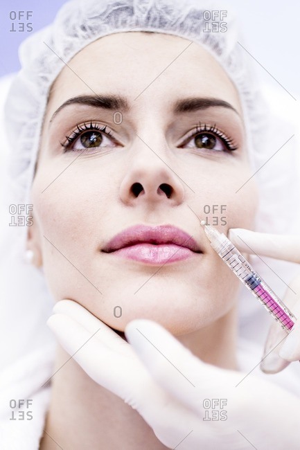 Young woman having a plasma and hyaluronic acid injection in her face to rejuvenate and smooth skin, close-up.