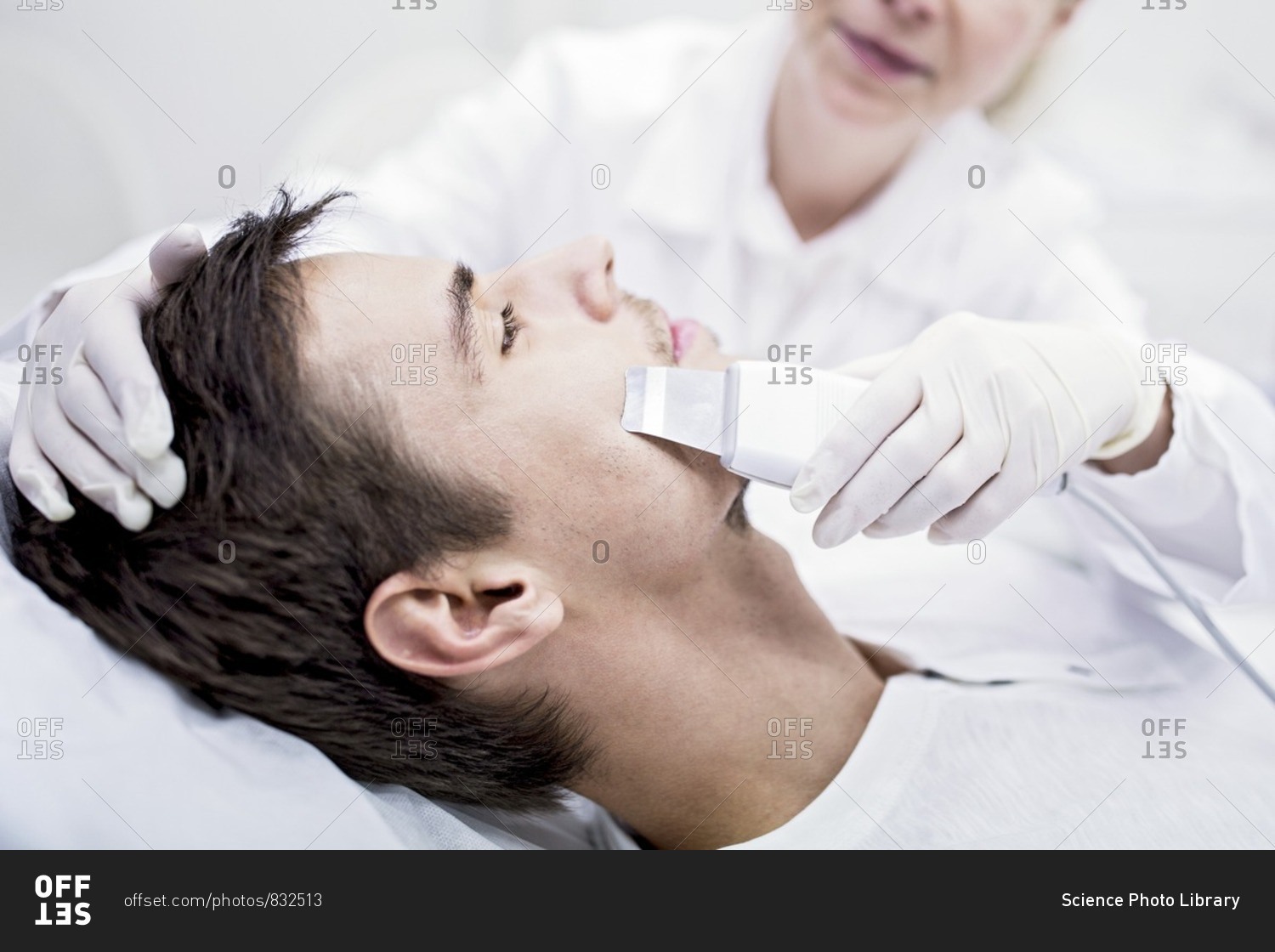 Dermatologist applying facial microdermabrasion treatment on man in clinic, close-up. The cosmetic procedure uses micro crystals to remove dead skin cells. This exfoliating treatment can stimulate the production of collagen and help improve fine lines and