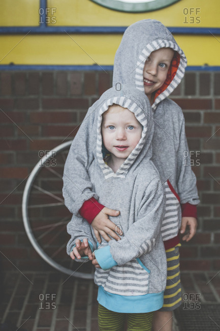Portrait of two siblings wearing similar hooded jackets