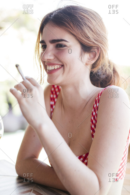 Portrait of happy happy woman smoking a cigarette outdoors
