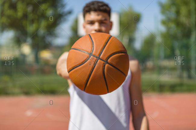Young man playing basketball- giving the basketball