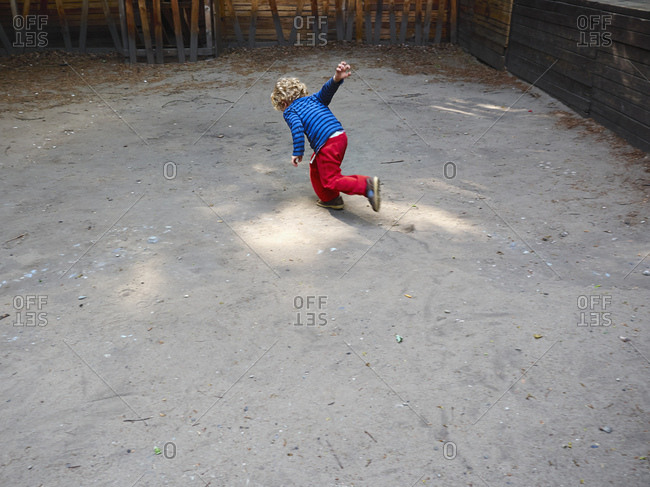 Back view of running little boy on playground