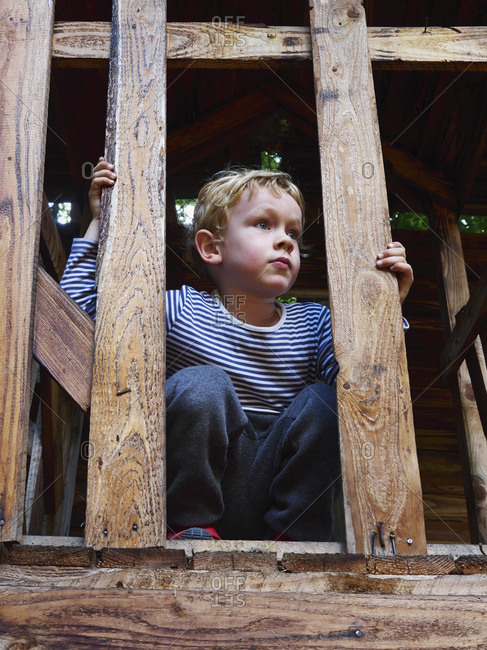 Portrait of littleboy crouching on climbing frame