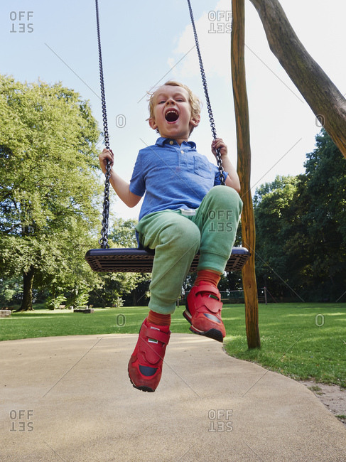 Portrait of screaming little boy on swing