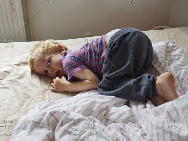 Portrait of little boy lying on bed