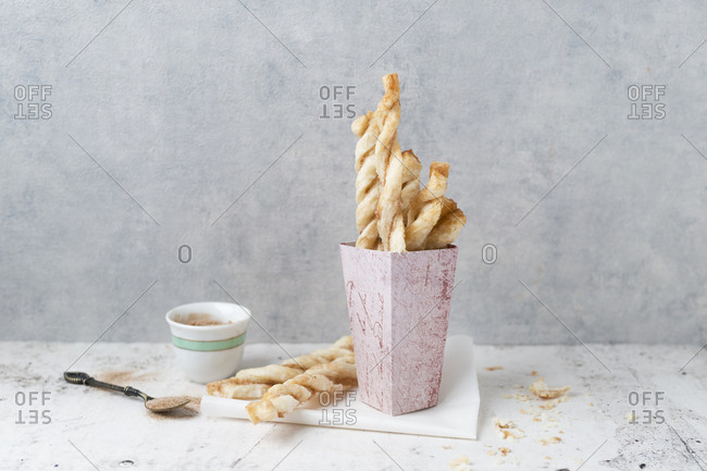 Paperbag of puff pastry sticks with sugar and cinnamon