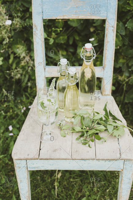Bottled peppermint juice and glass on a chair