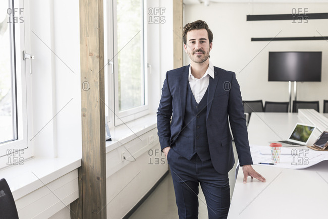 Confident businessman standing in boardroom