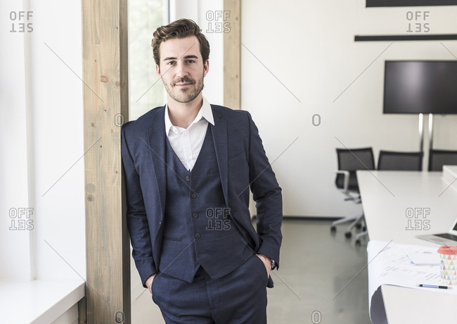 Confident businessman standing in boardroom