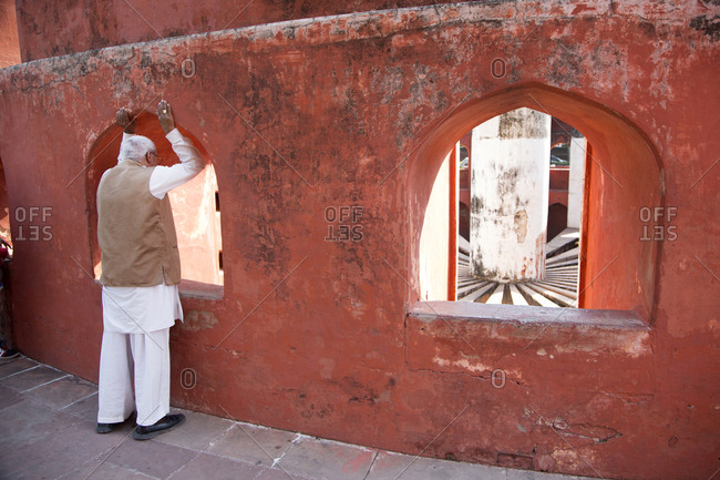 Man looking through arch at the Jantar Mantar Astronomical Park, New Delhi, India