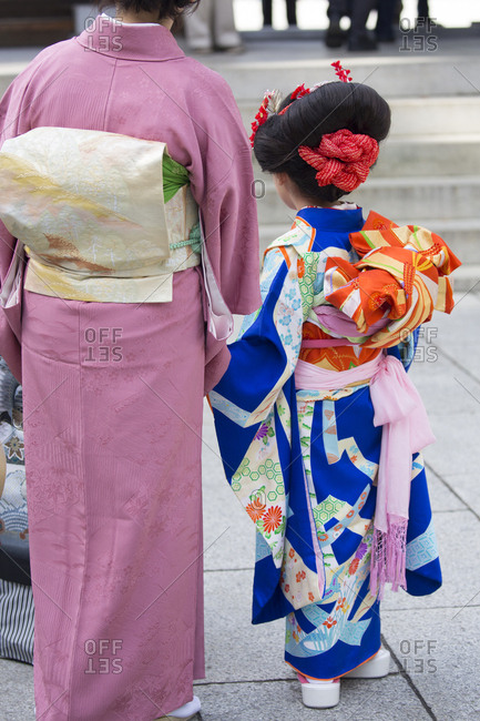 Mother and girl at Meiji Jingu shrine for prayers, Tokyo, Japan