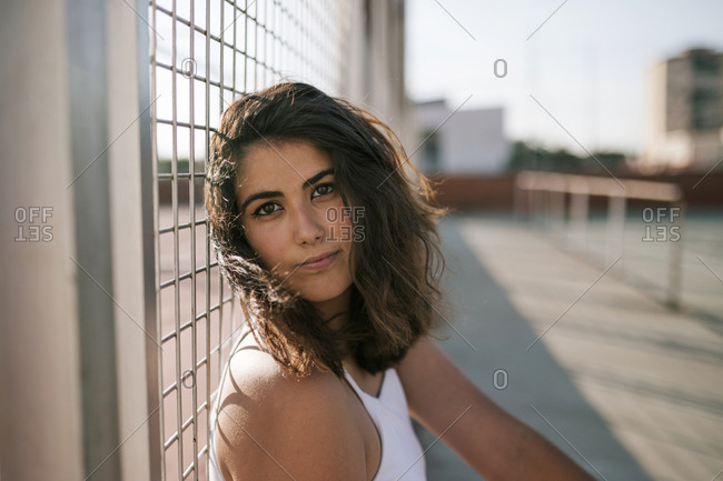 Portrait of a young woman resting on a metal grid